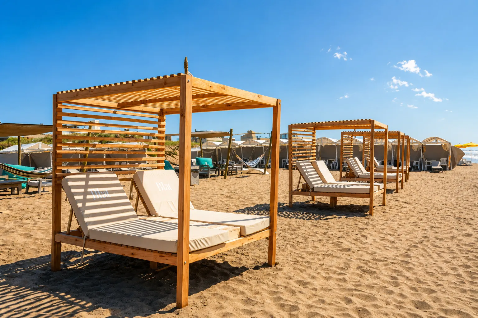 Camas balinesas de madera con pérgola sobre la arena