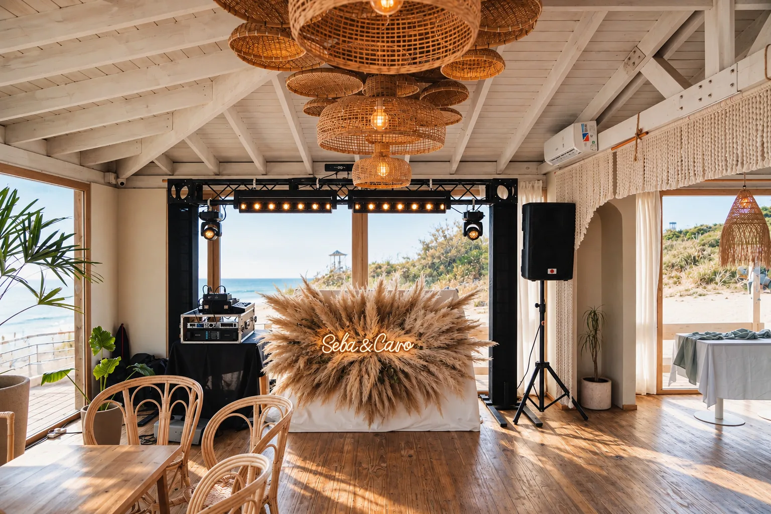 Salón montado para una fiesta, con cabina de DJ, luces y el ventanal al mar